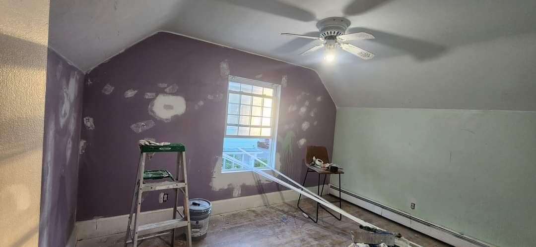 Purple bedroom wall with patched drywall spots before painting