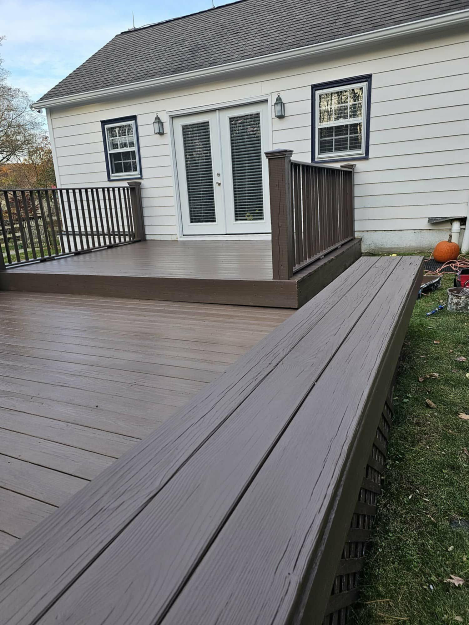 After: the same deck refinished in a rich brown stain with a built-in bench
