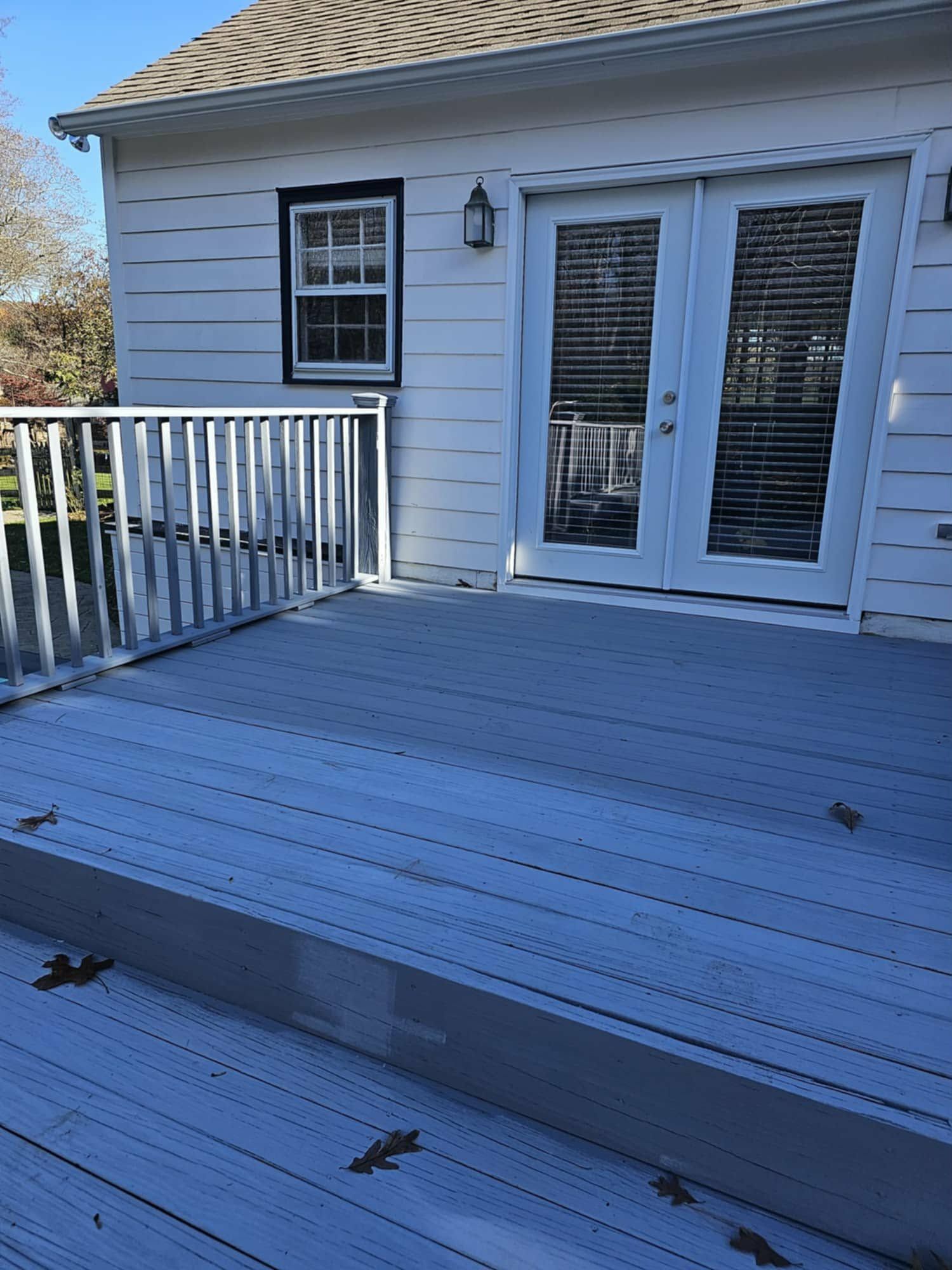 Before: backyard deck with worn gray paint and white railings