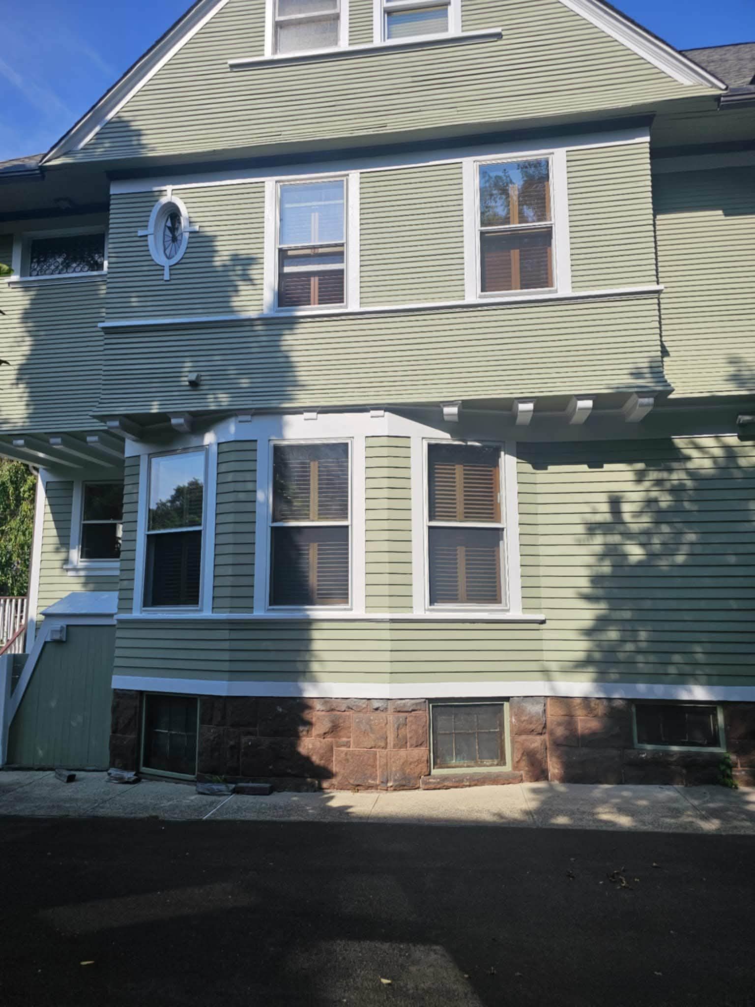 After: the same side repainted sage green with crisp white trim