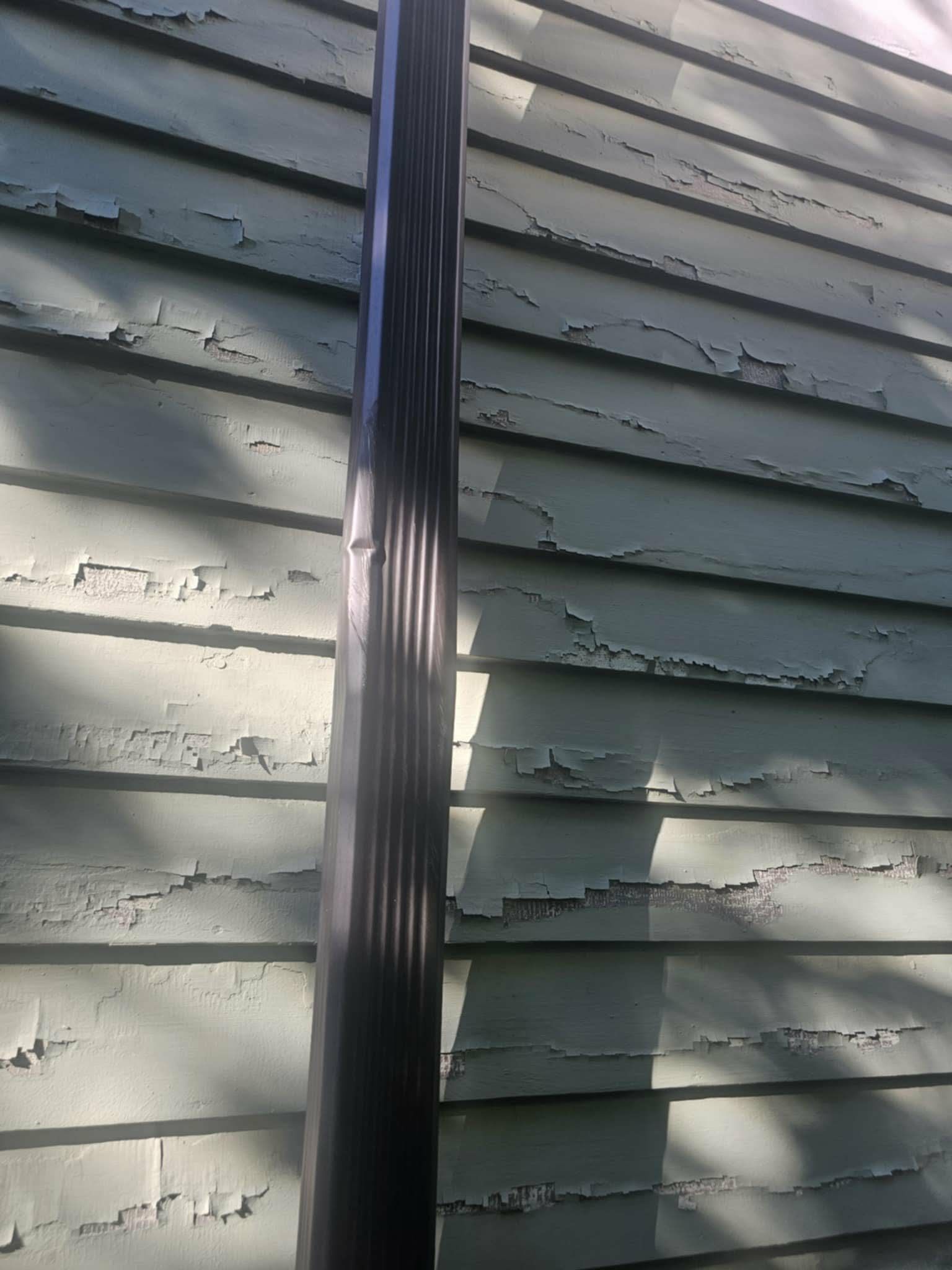 Close-up of old paint peeling off the clapboard siding before prep