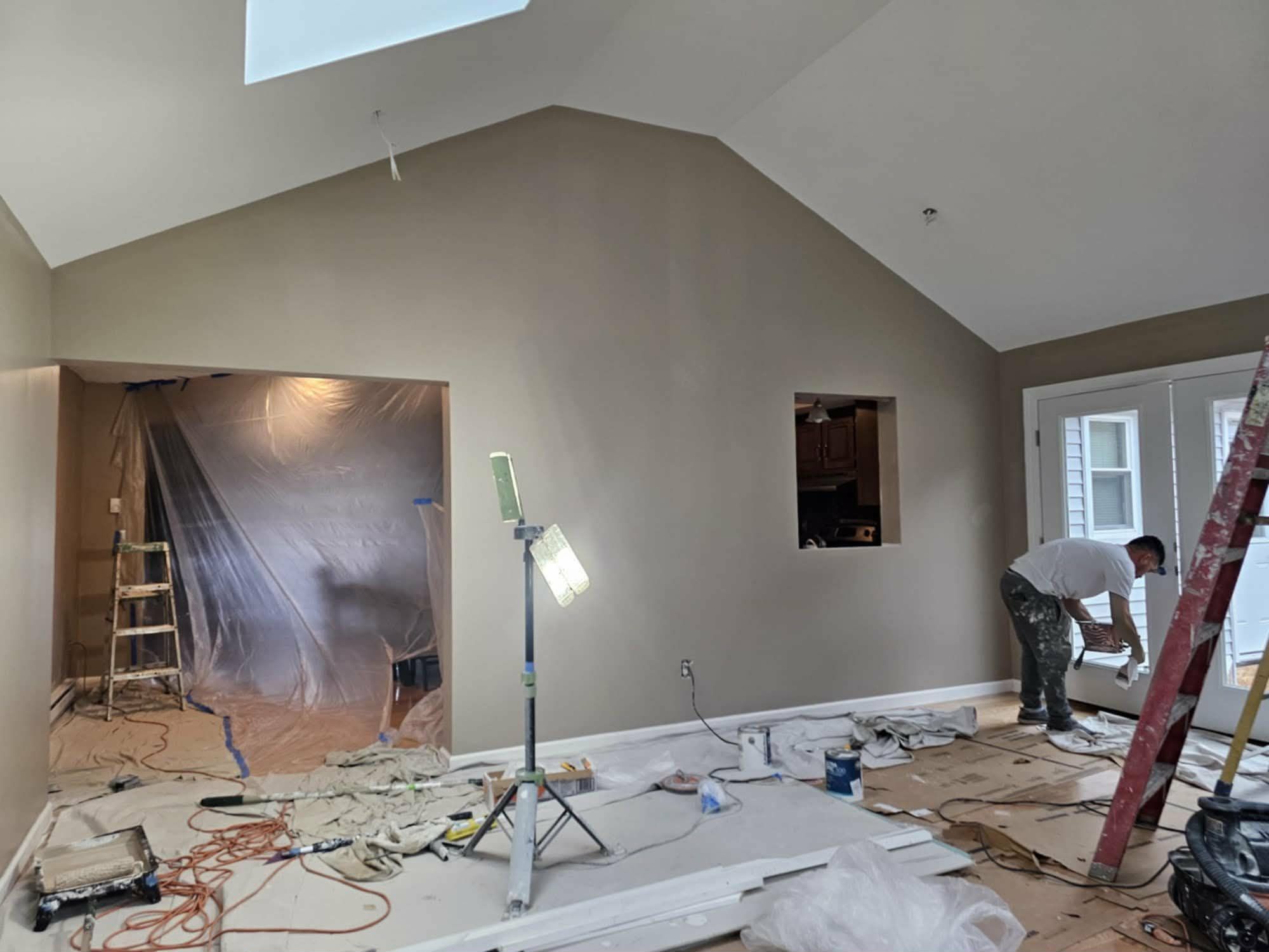 Vaulted room painted a warm gray, with the last trim work underway